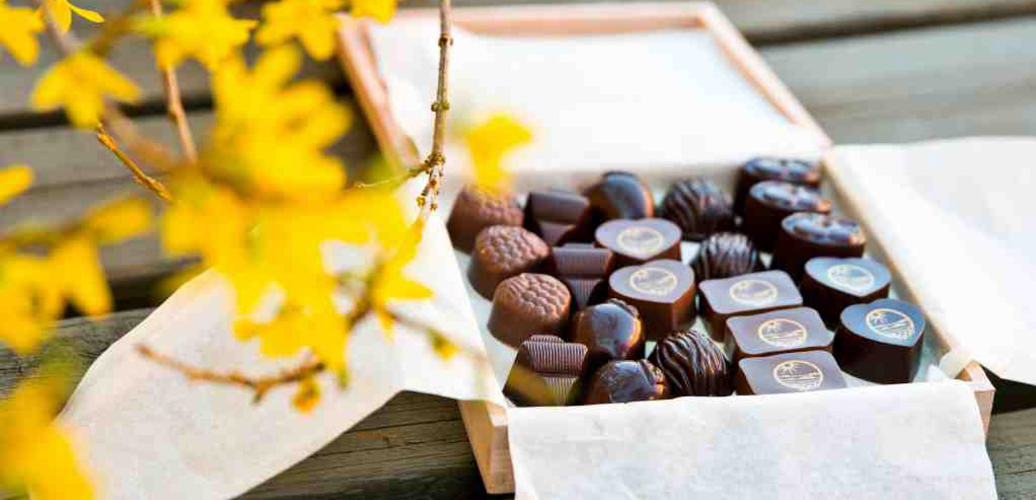 Åben, indbydende æske med fyldte chokolader.