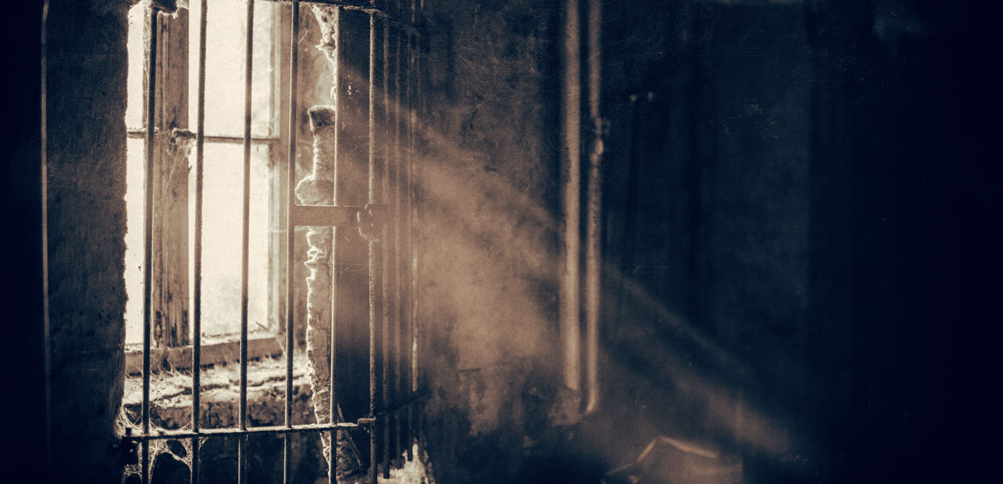 Mørke, uhyggelige omgivelser, hvor der strømmer lys ind ad et gammelt, støvet vindue.