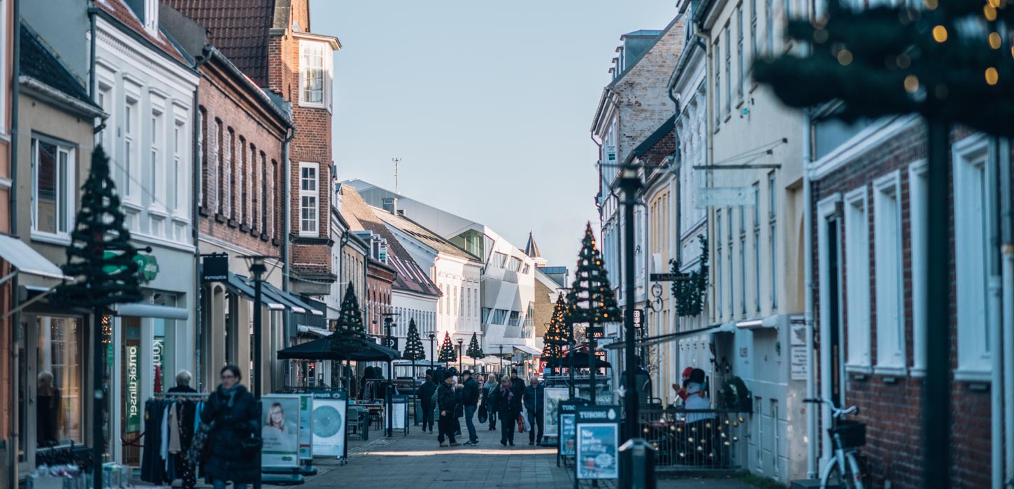 Ned langs en gågade er dekorationer formet som juletræer på begge sider af gaden