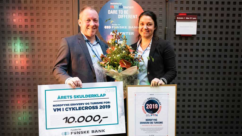 To personer på en scene, der har fået overrakt et gavekort på 10.000 kr. for Årets Skulderklap 2019