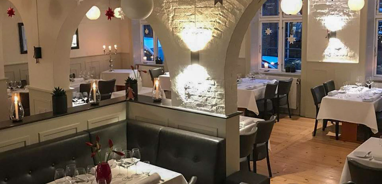 Hvidt og brunt interiør i hyggelig restaurant og vinbar.