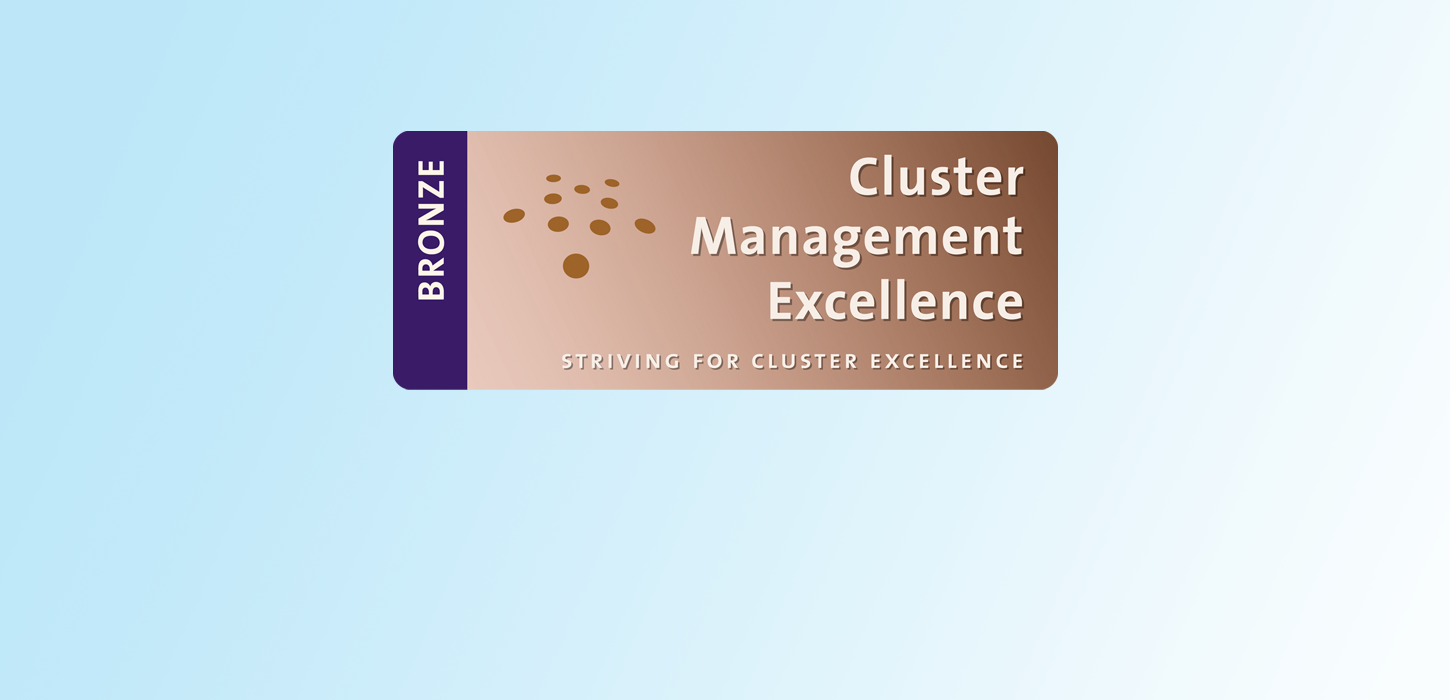 Bronzefarvet plastikkort med teksten Cluster Management Excellence på himmelblå baggrund.