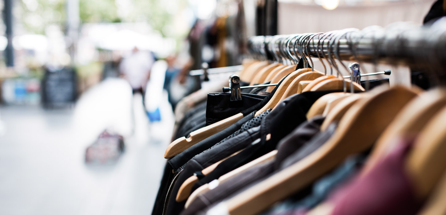 Et stativ med en række bøjler beklædt med tøj.