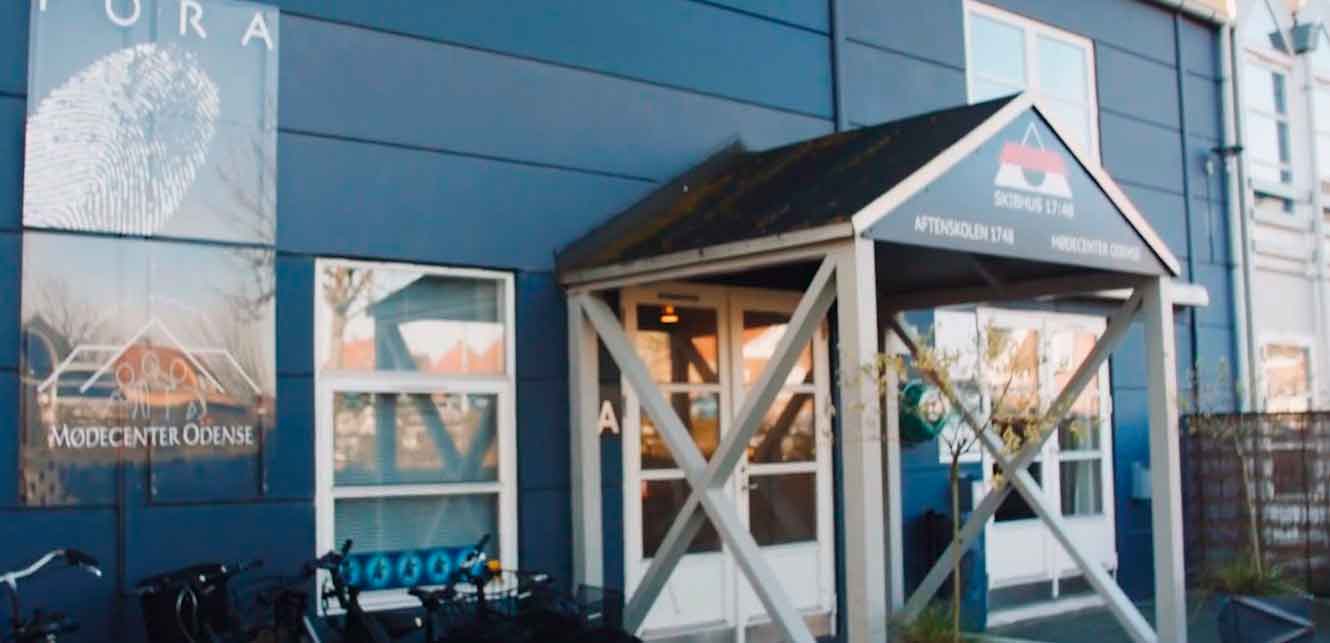 Mørkeblå bygning med fremstående indgang.