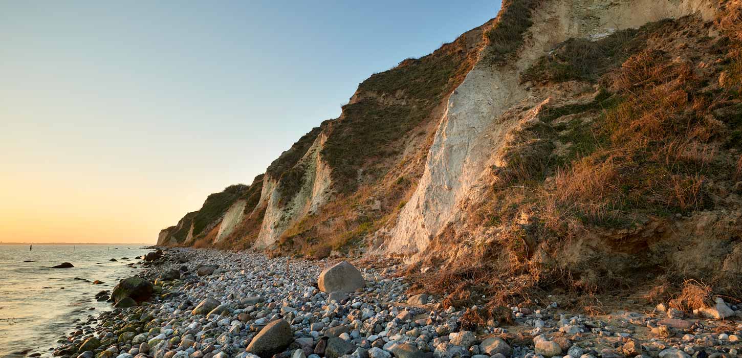 Stejl klint ud til sten og strand
