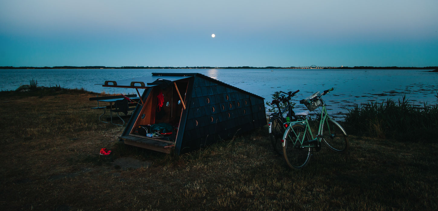 Shelter ligger ud til havet og to cykler står ved siden af.