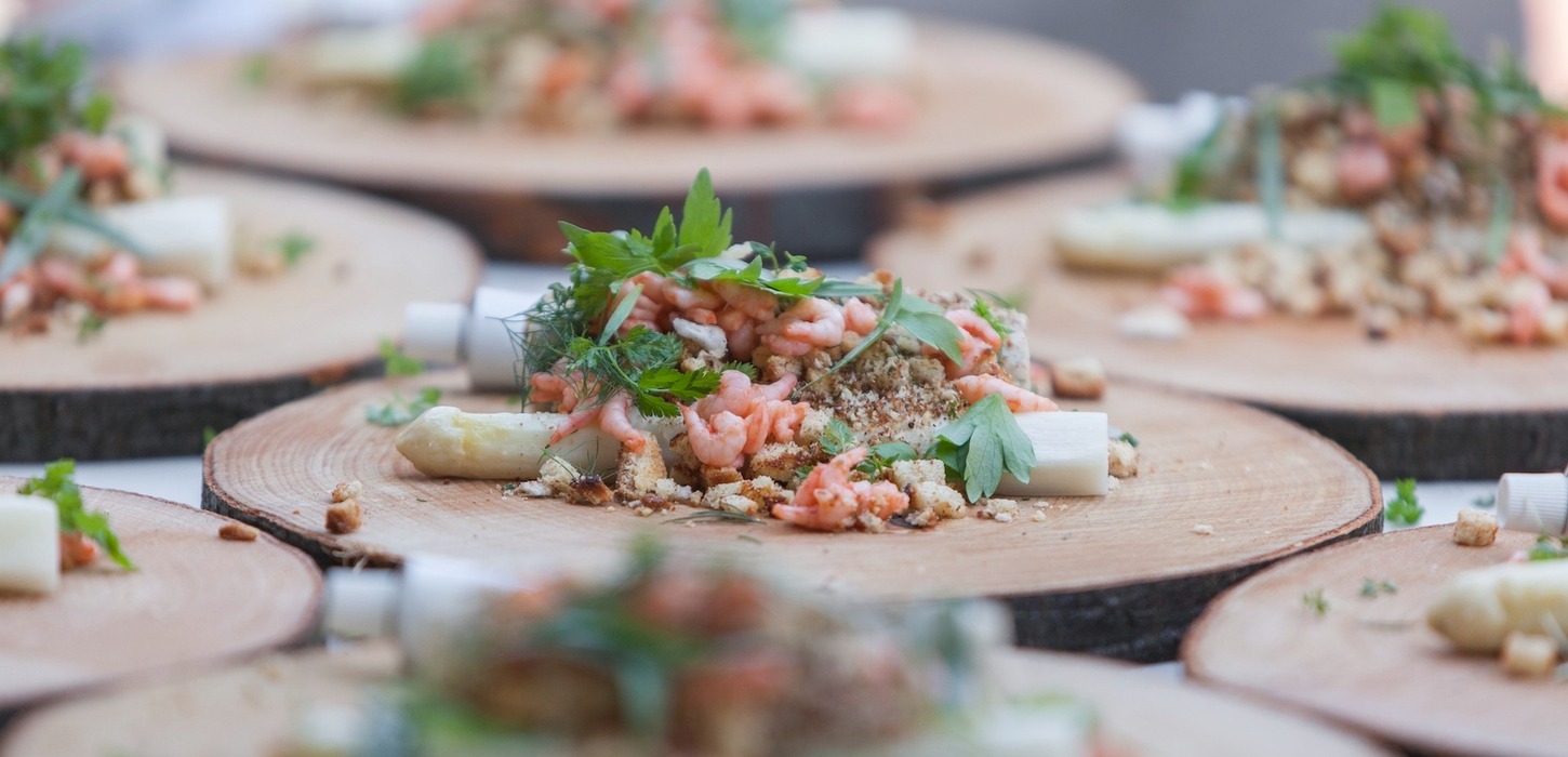 Anretning med asparges-ret på rustikke plader af udskåret træstammer