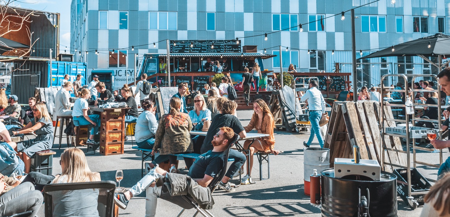 En flok mennesker sidder udenfor på et Street Food-marked.