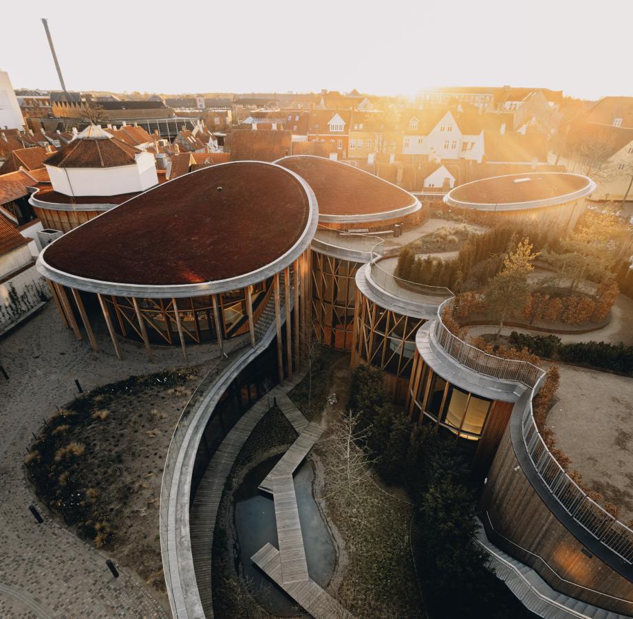 Dronebillede af H.c. Andersens hus museum. Store buede bygninger med haver på tagene. 