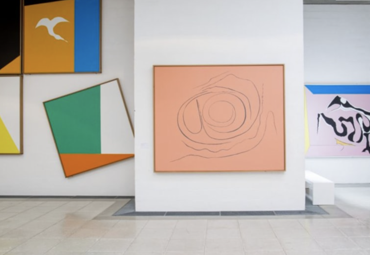 Billeder i forskellige størrelser og farver hænger på en væg på museet Trapholt.