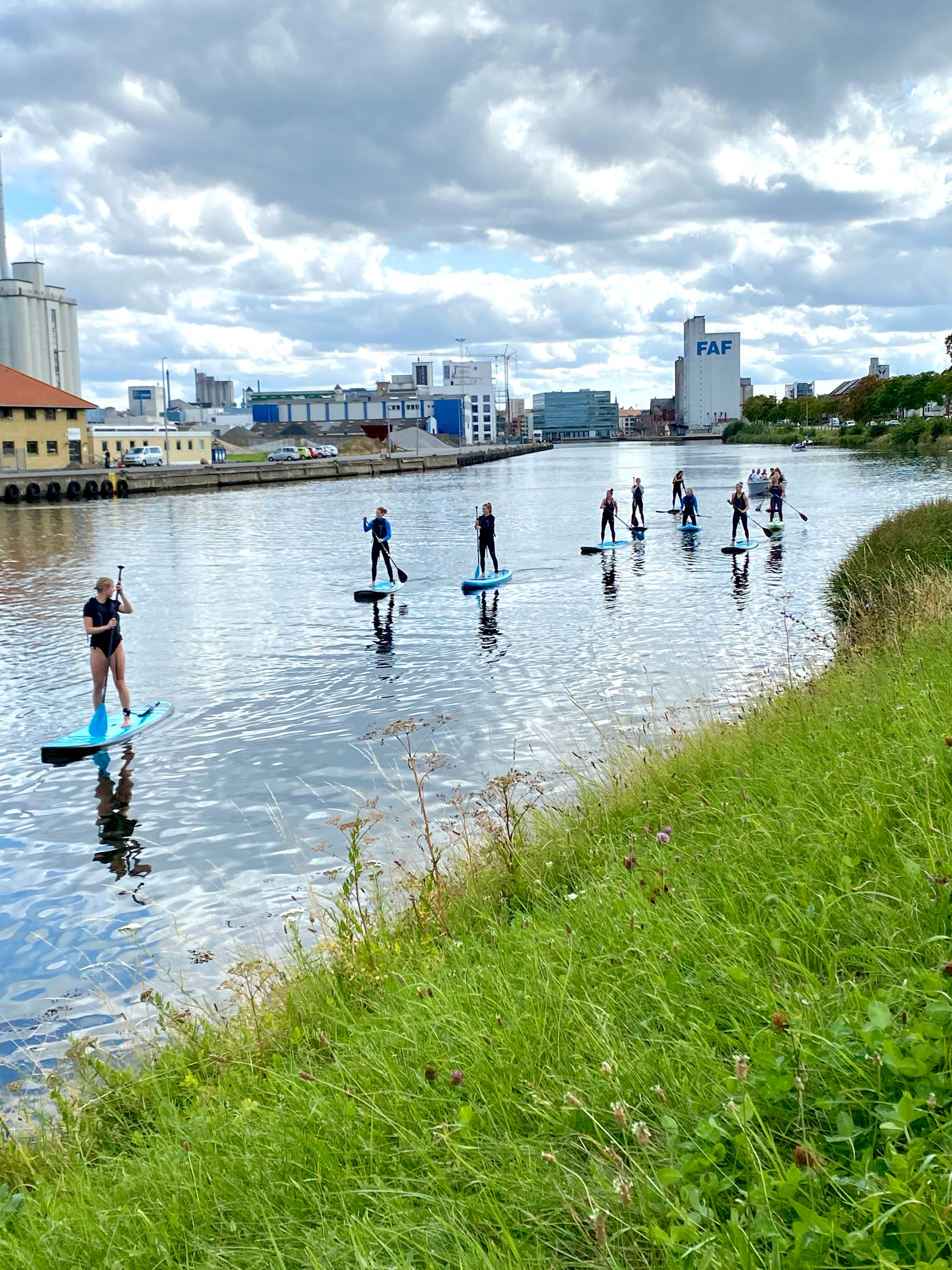 Odense kanal med ni mennesker på stand up paddle board
