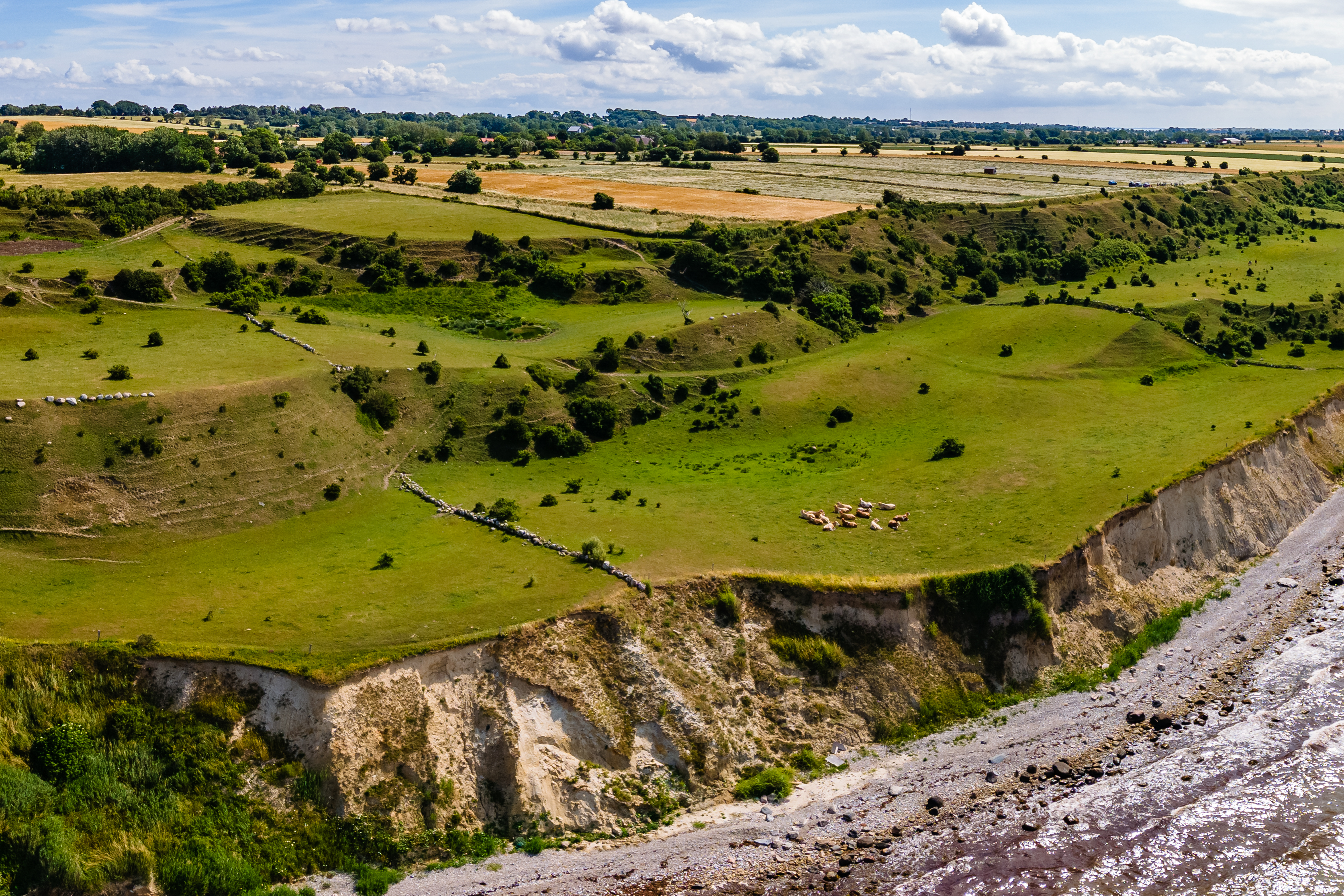 Dronebillede af en stor klint, som ligger ud til havet.
