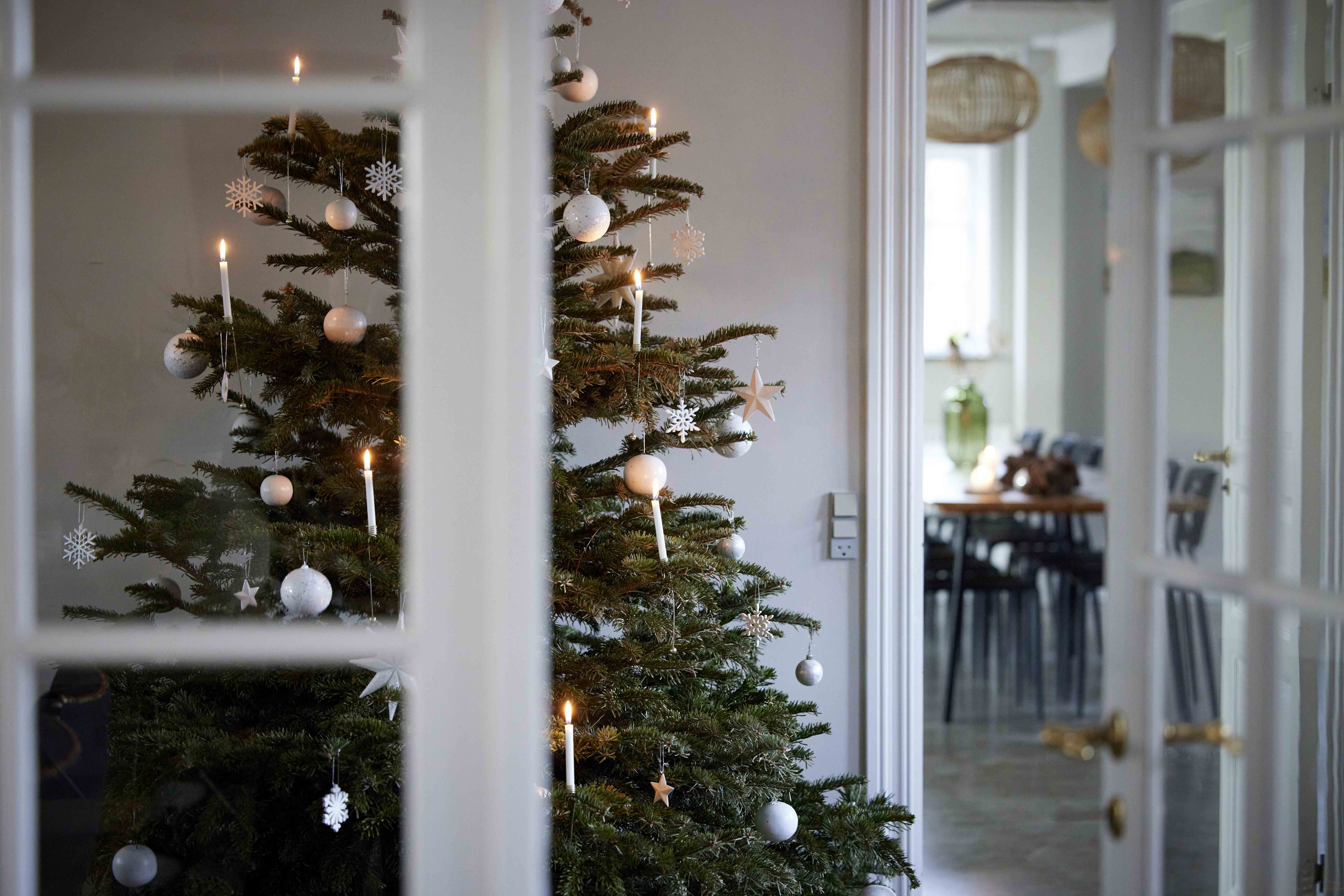 Pyntet juletræ i i et lyst rum