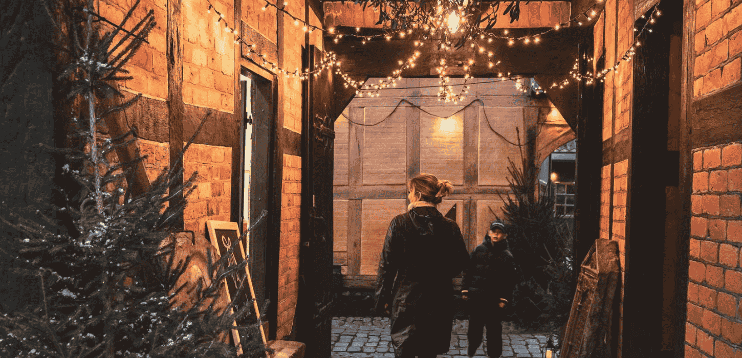 Stemningsfuld stræde med julebelysning og juletræ