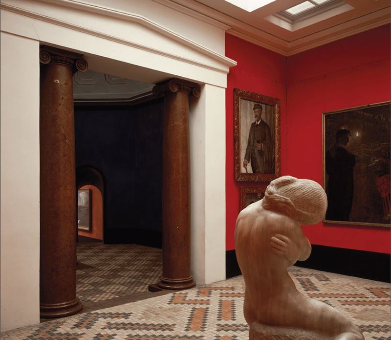 En kunsthal med røde vægge, massive port og klinkegulv