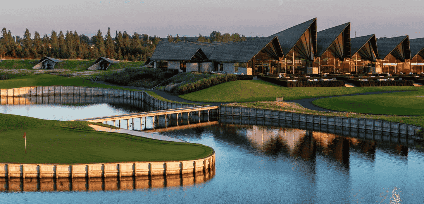 En golfbane med sø og stor ny-nordisk bygningskompleks