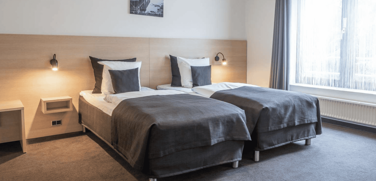 Et hotelværelse med opredte enkeltsenge