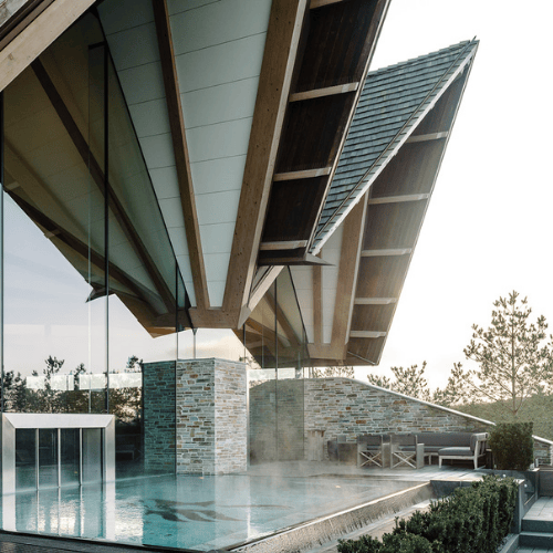 Et udendørs spabad der forbinder et indendørs bassin med et udendørs