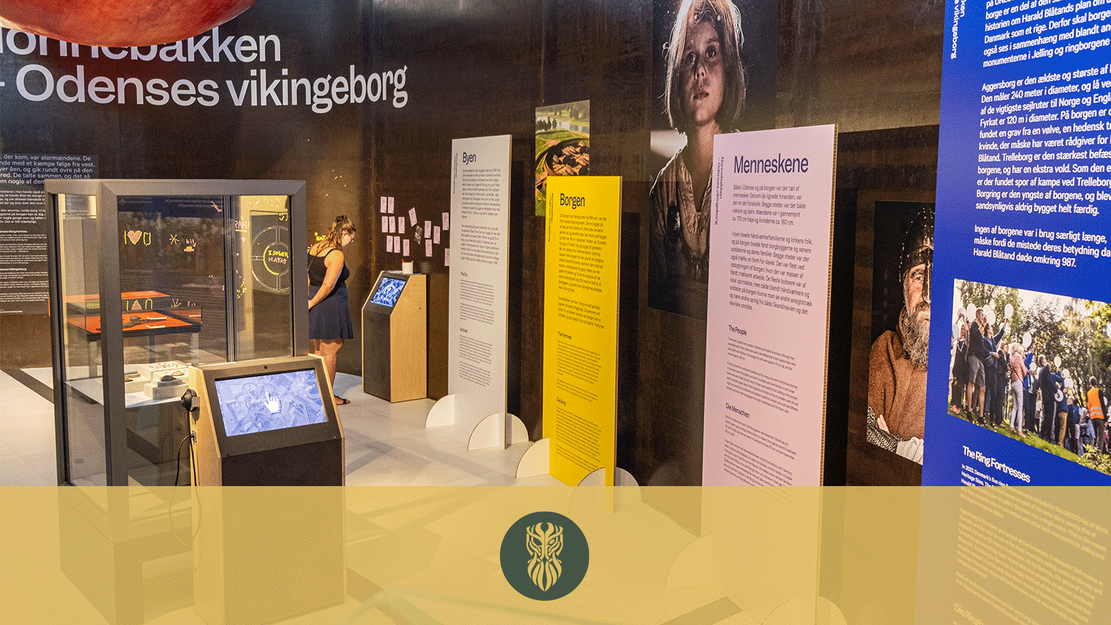 En udstilling på et museum med farverige plancher, montrer og billeder af vikinger