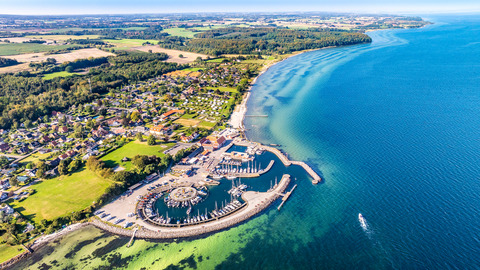 Dronebillede af Lundeborg havn, som er en marina med runde former og med en lille landsby tæt ved