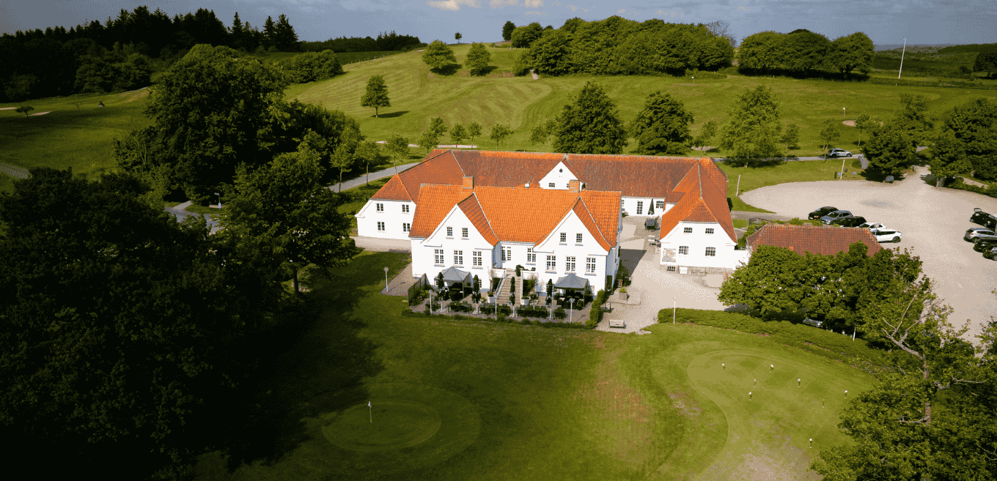 Hvid golfklub omkranset af træer og skov