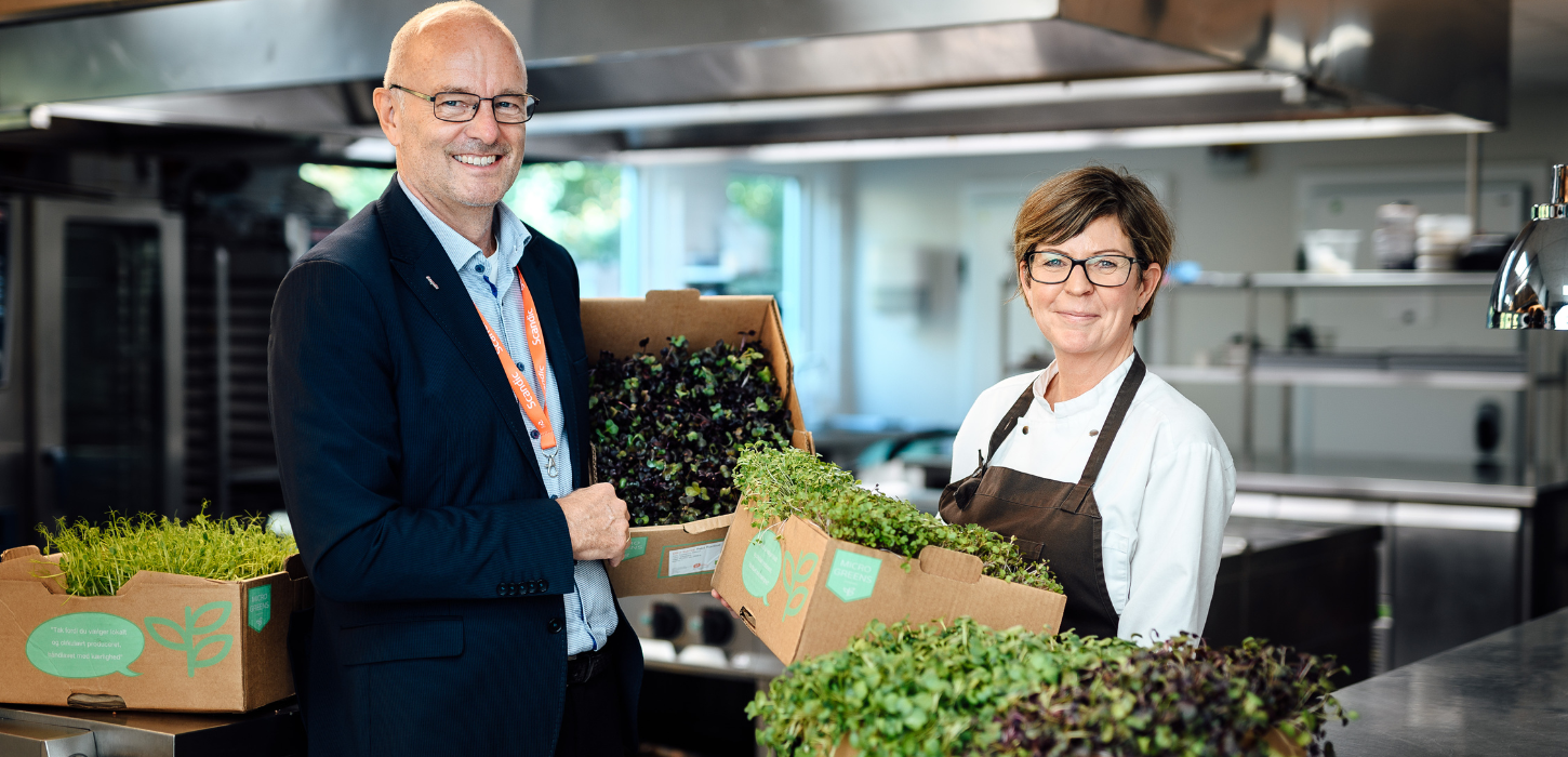 Hoteldirektør og køkkenchef med kasser af spirende grønt