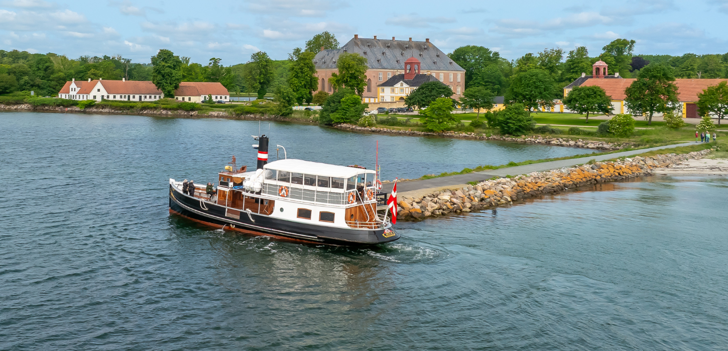 Den gamle færge MS Helge lægger til ved en stenkaj ud foran Valdemars Slot