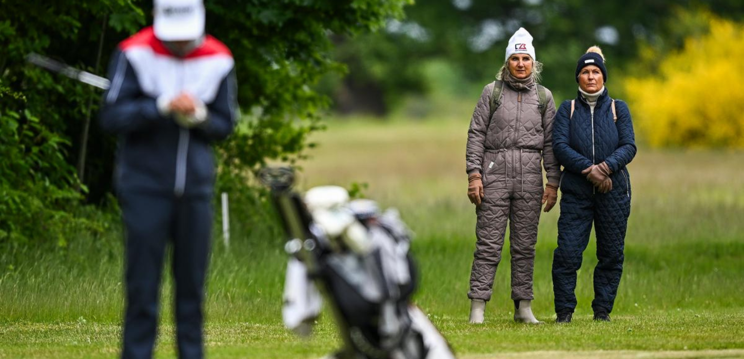 To kvinder ser på golfspiller