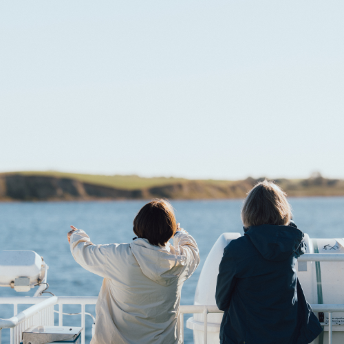 To kvinder står med ryggen til og kigger ud fra færge på Øhavet