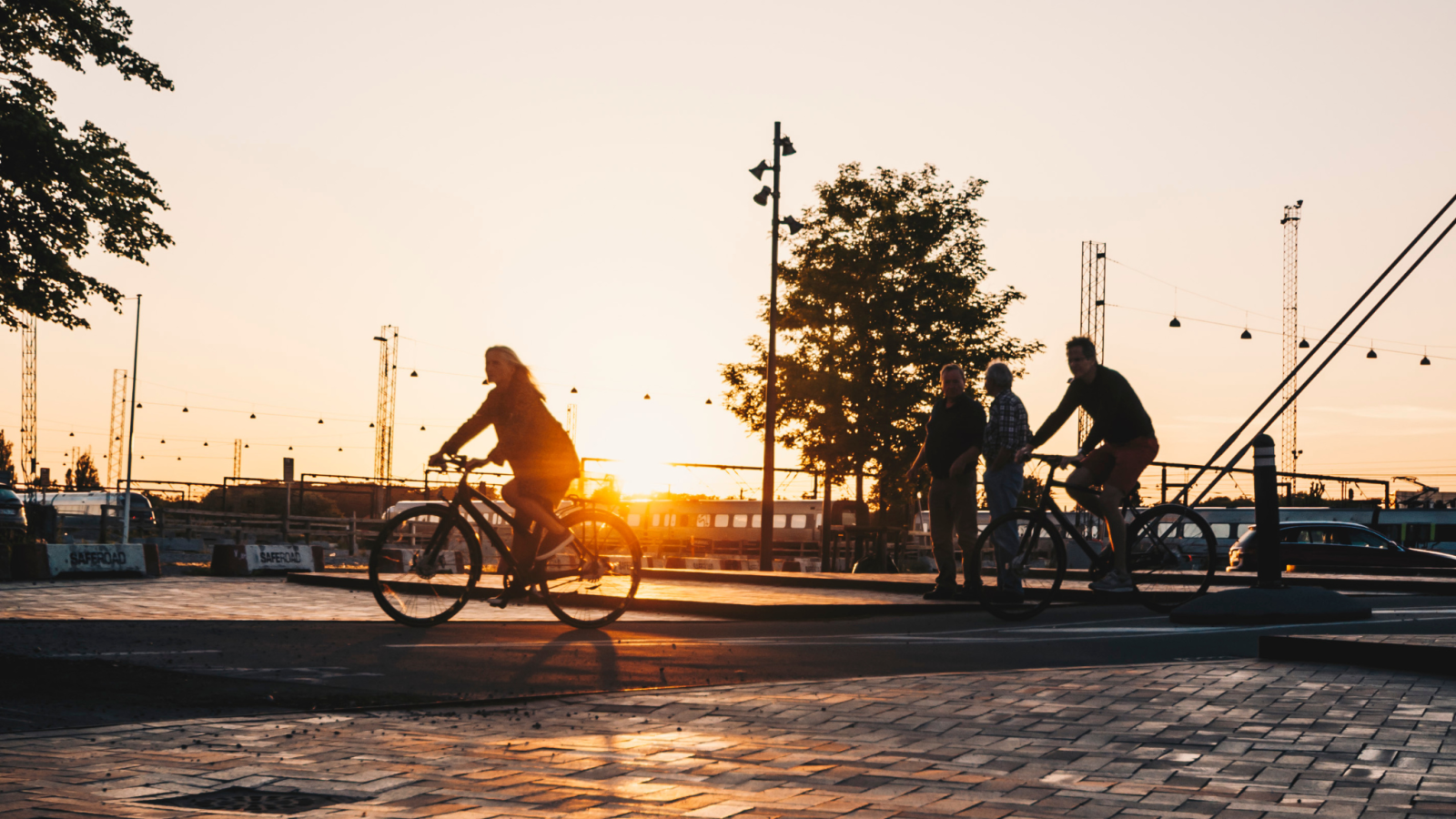 Cyklister i bymiljø i solnedgang