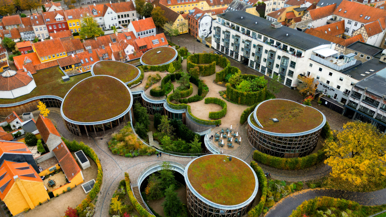 Dronefoto af H. C. Andersens hus, der består af en klynge af runde bygninger med mos på taget