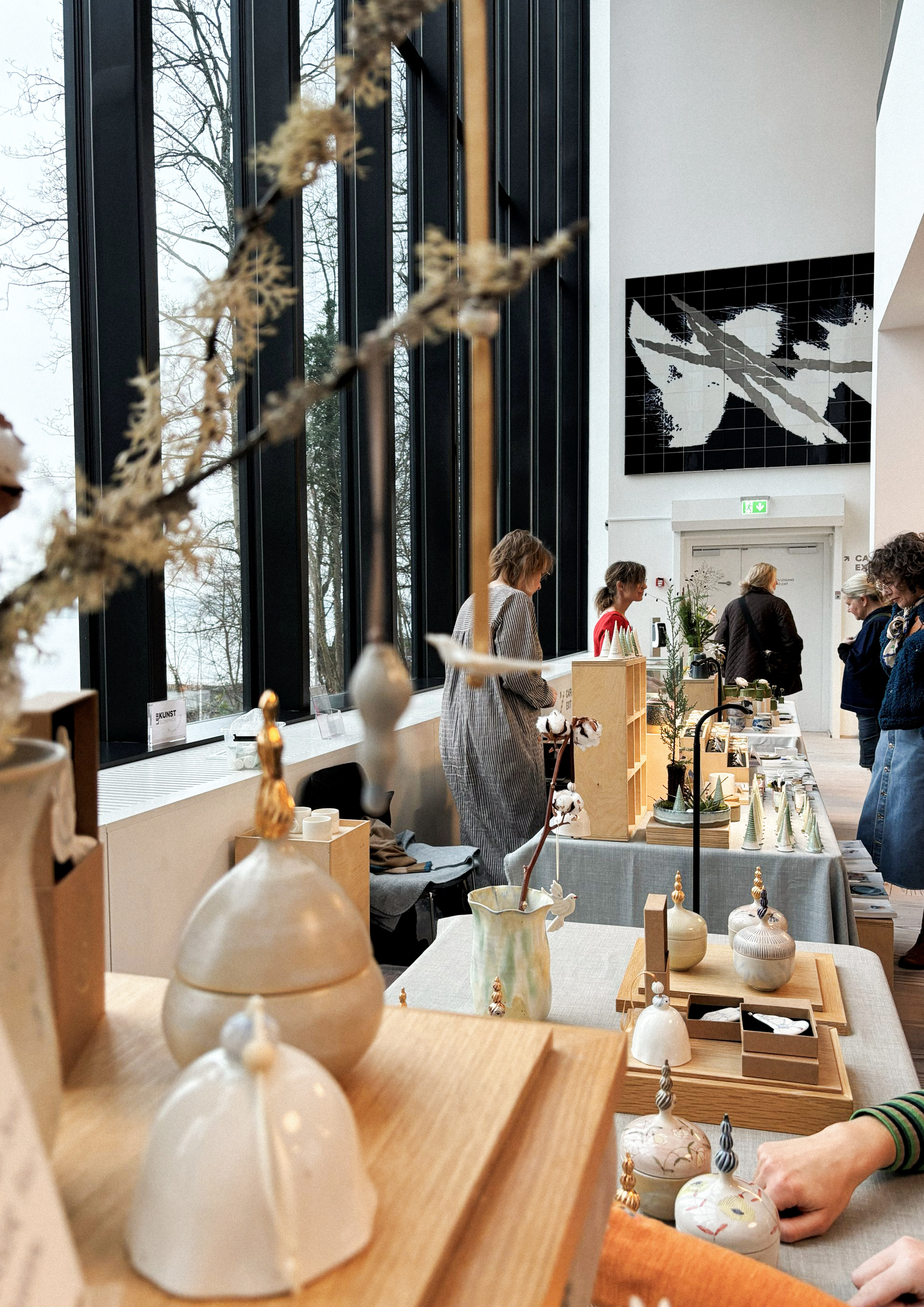 Julemarked på keramikmuseet CLAY, hvor keramiske produkter er sat frem på træstandere, og gæster går og kigger