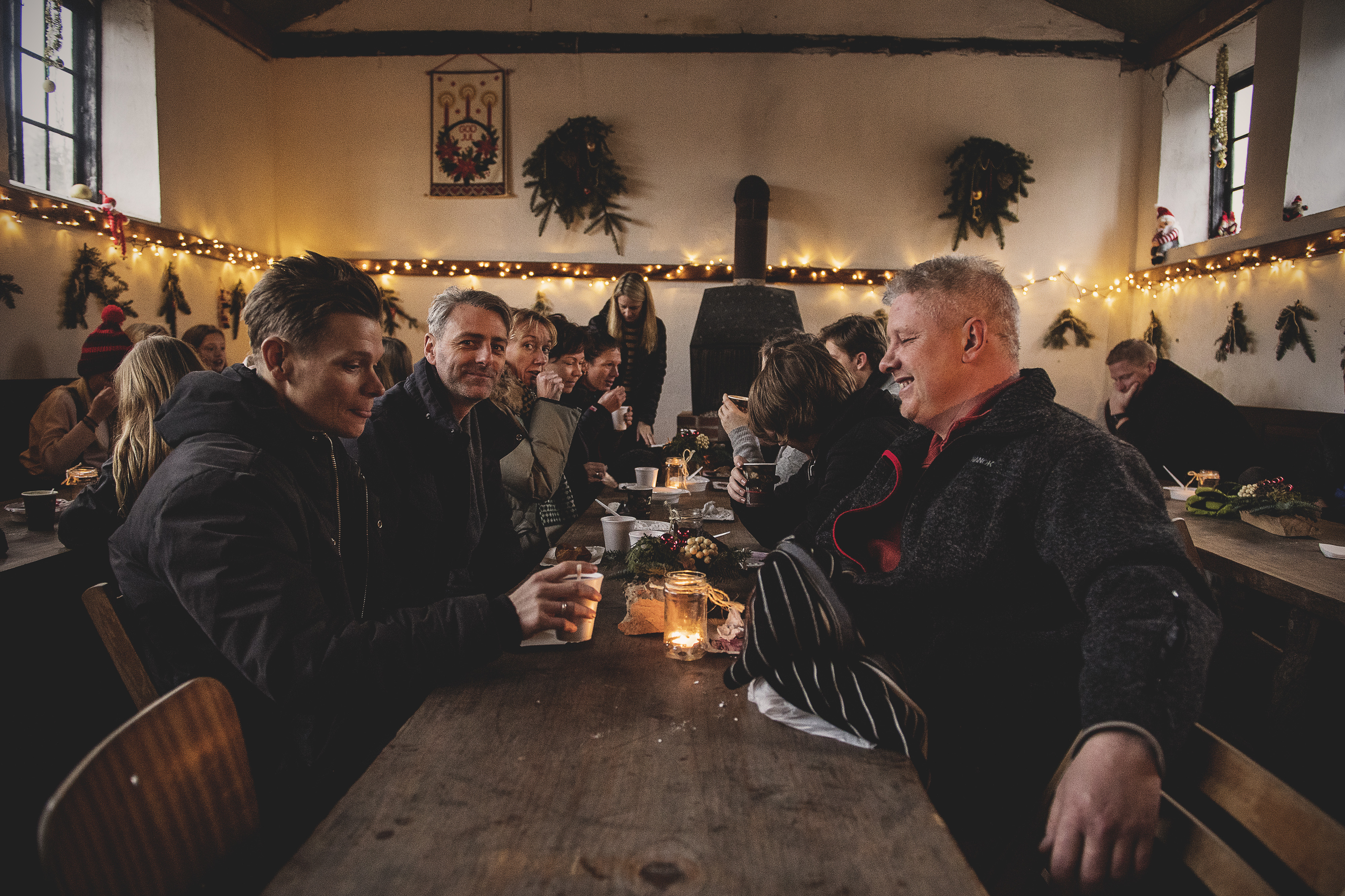 En gruppe mænd sidder rundt om et bord til et julemarked ved Langesø
