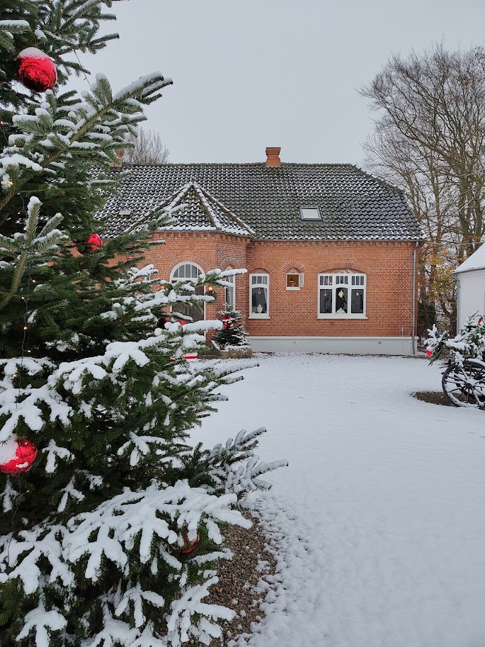 En rødstenet herregårdslignende bygning dækket af sne