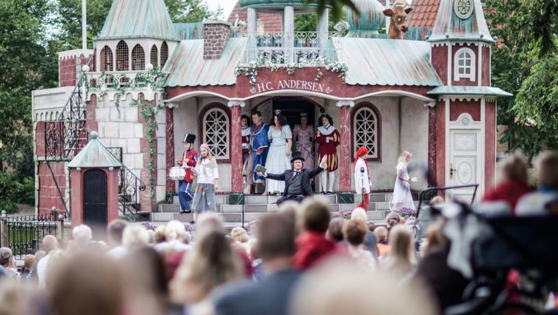 Børn udklædt som prinser og prinsesser optræder på scene der forestiller et slot.