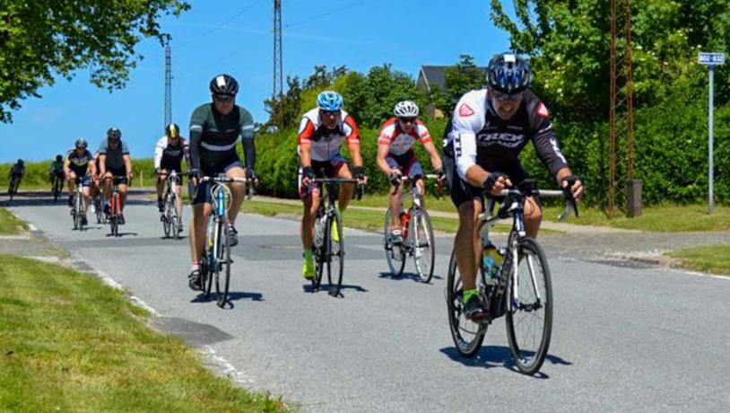 Cykelryttere på vej ind ad lille bygade.