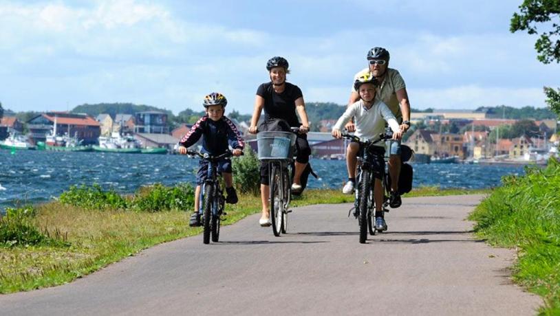 Familie cykler langs kysten på Thurø