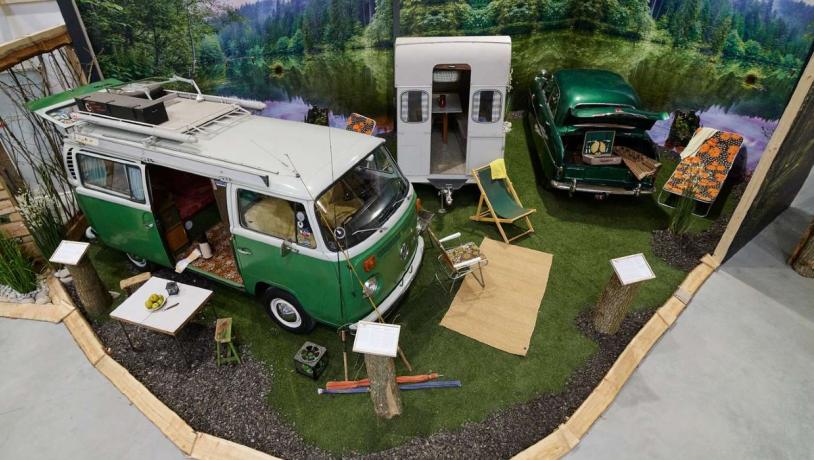 Gammel grøn retro- camping-van fra VolksWagen er udstillet med forskellige tilsvarende retro-campingeffekter rundt om.