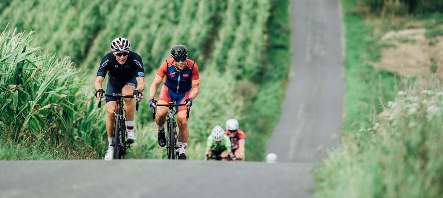 Cykelryttere på vej op ad stejl bakke.