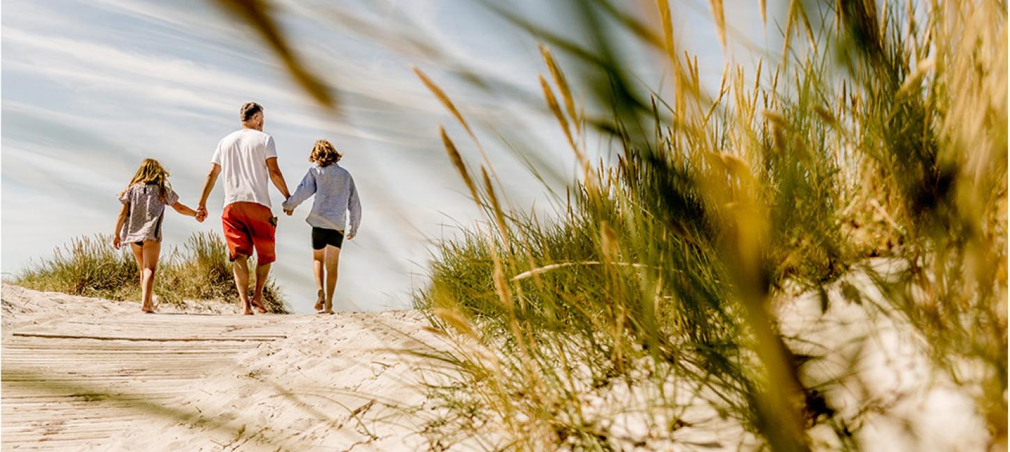 Family walking hand in hand along the beach