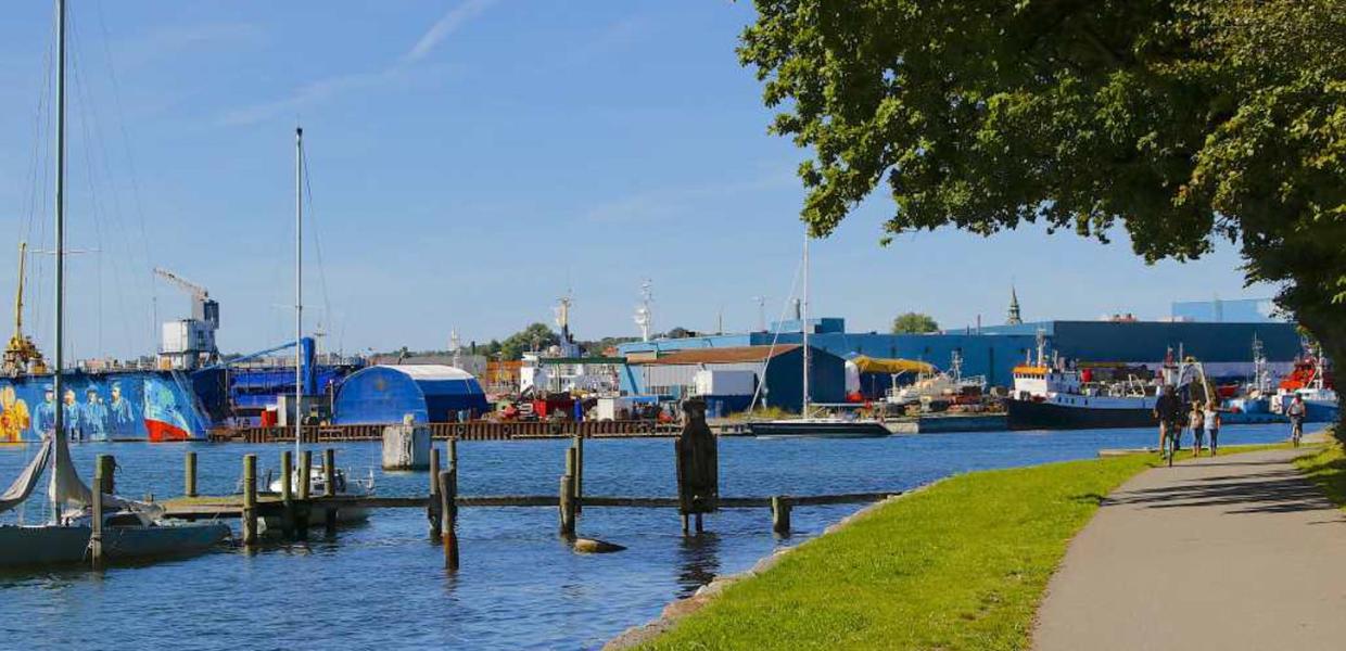 Cykelsti lige ud til vandet ved Svendborg Sund. Bådebro og industribygninger i baggrunden.