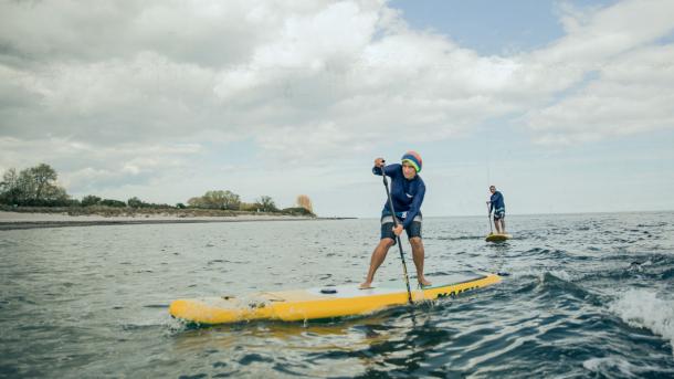 To personer på stand up paddle boards i vandet