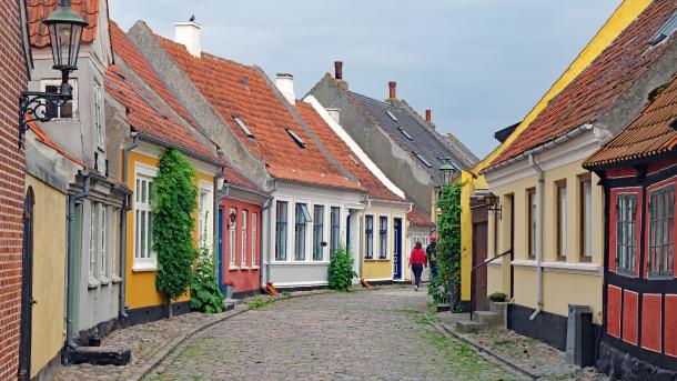 En brostensgade med små, farverige huse i Ærøskøbing