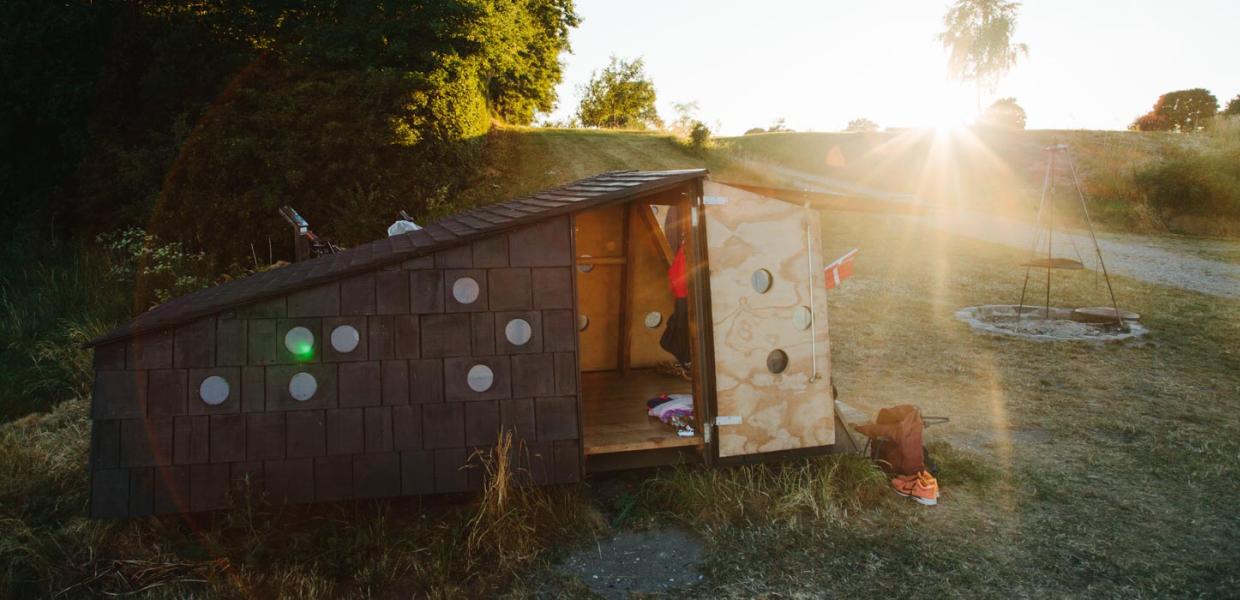 Shelter omringet af naturlige omgivelser. Flot solskin i baggrunden.