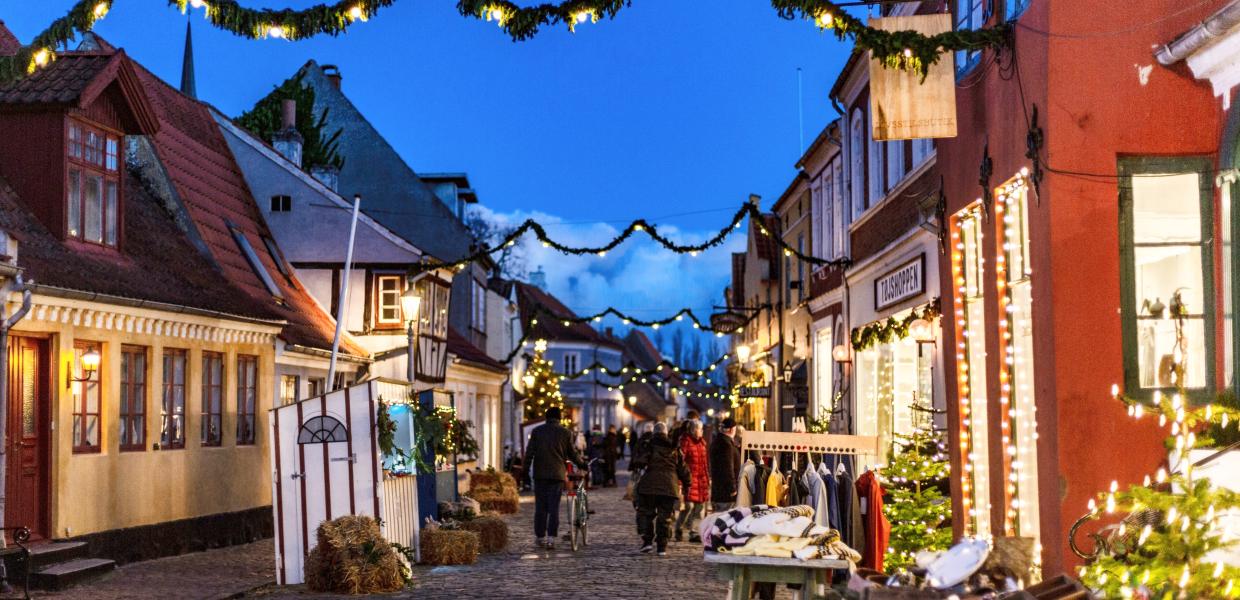 Julelys ned langs en lille gade med boder på begge sider