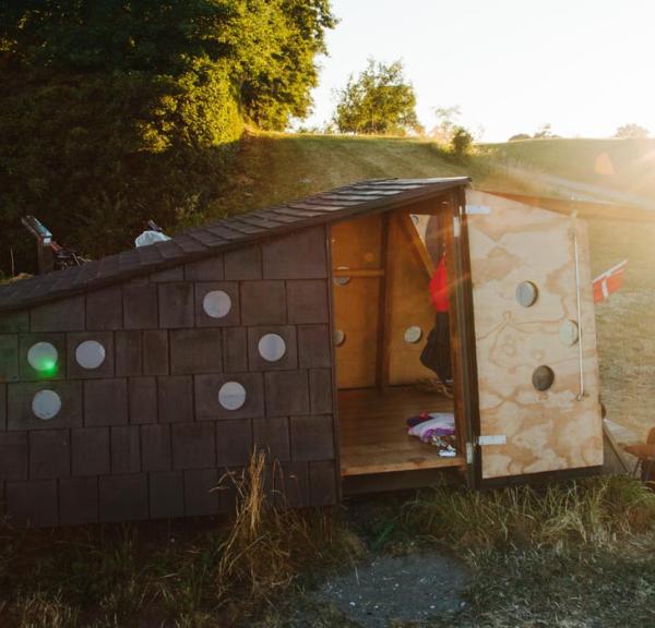 Shelter omringet af naturlige omgivelser. Flot solskin i baggrunden.