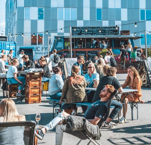 En flok mennesker sidder udenfor på et Street Food-marked.