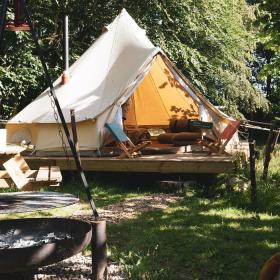 Glamping telt står midt i grønne og hyggelige omgivelser.