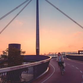 Odense Byens bro i solnedgang med cyklist