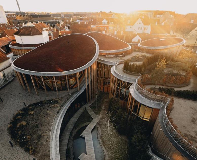 Dronebillede af H.c. Andersens hus museum. Store buede bygninger med haver på tagene.